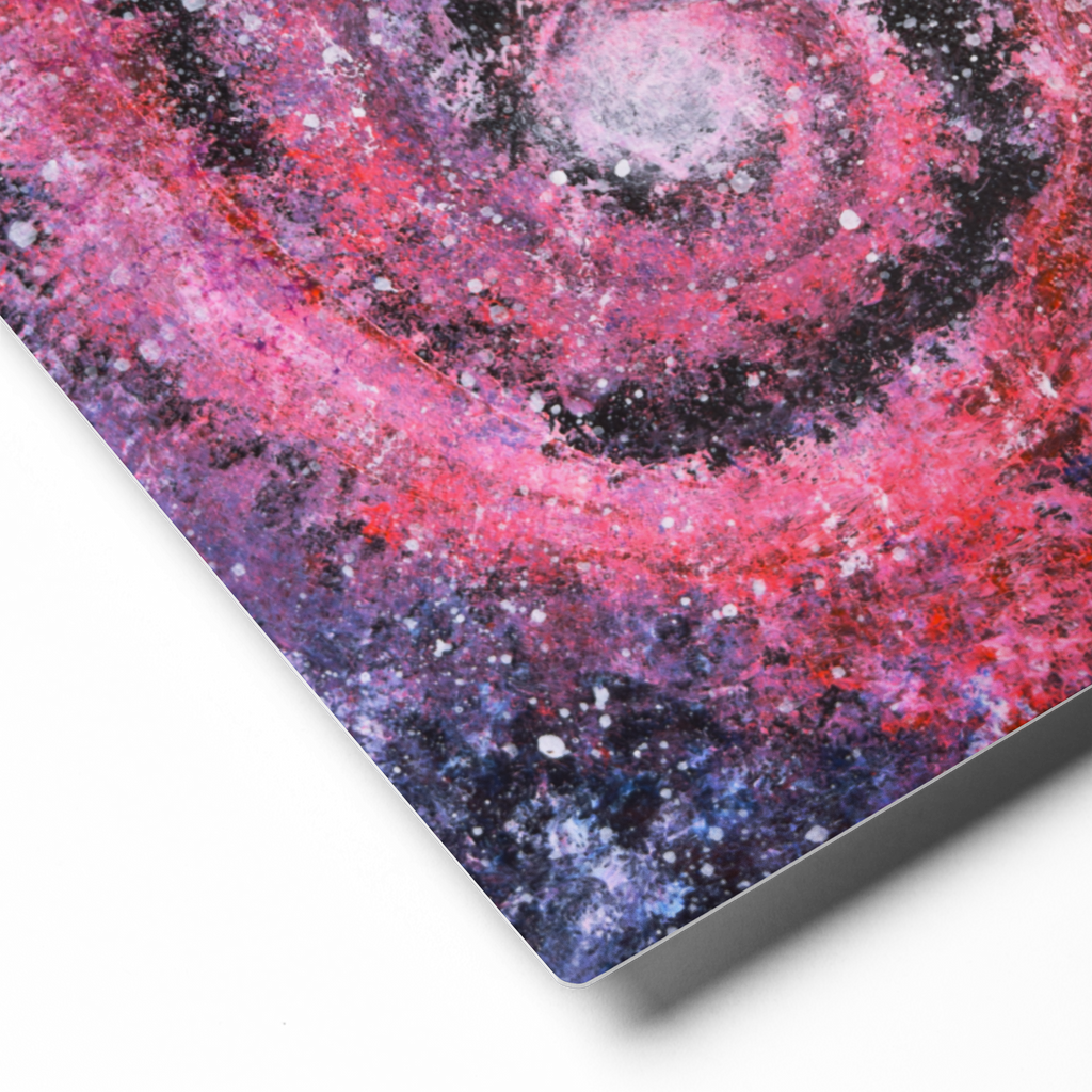 Close-up of a galaxy-themed aluminum print with pink and purple hues on a white background
