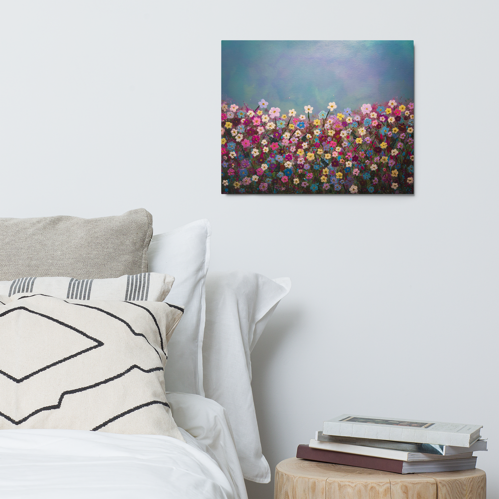 Colorful floral painting above a bed with pillows and books on a nightstand.